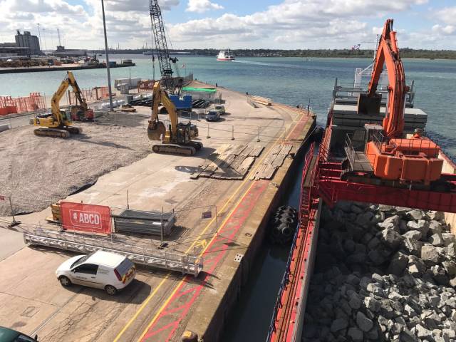 ABCO Marine have been contracted on a project at Eastney, Portsmouth. The Northern Ireland based firm sourced and procured rock armour for the project from Norway from where vessels offloaded above in Southampton Port for temporary stockpiling. Afloat adds that in background is one of a trio of Red Funnel 'Raptor' class car ferries heading down Southampton water for Cowes (East) on the Isle of Wight. 