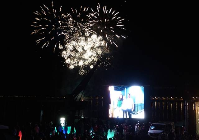 Fireworks with all the trimmings – celebration over Dun Laoghaire from the National YC while on the screen are Silver Medallist Annalise Murphy, her training partner Sara Winther, and longtime coach Rory Fitzpatrick