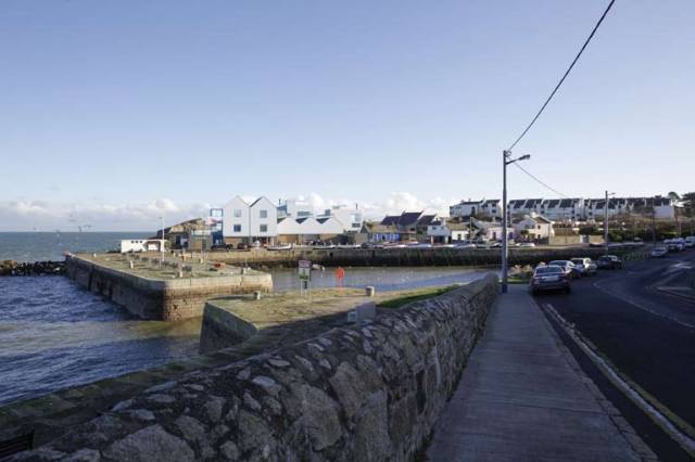 Local anger over decision to allow Bartra Capital build luxury villas and apartments at the coastal inlet at Bulloch Harbour, Dalkey in Co. Dublin and above an illustration of the proposed development.