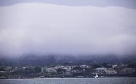 A lone Fireball dinghy sails on Dublin Bay with a backdrop of heavy mist on Killiney Hill on Saturday