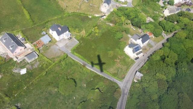 Aerial shot over Aran Islands with shadow of aircraft 