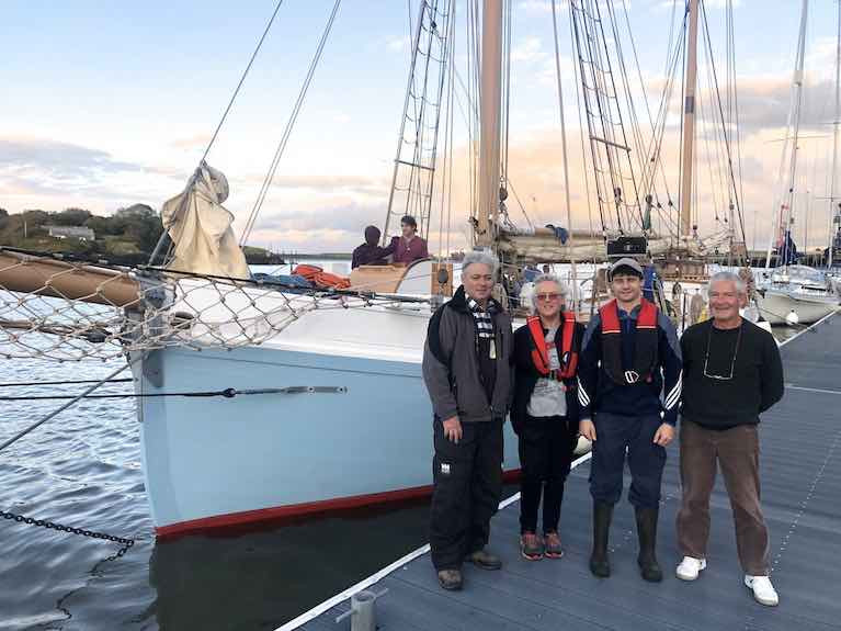 Back at her real home after 93 years – the 56ft 1926-built restored Limerick Trading ketch Ilen takes up her berth in Foynes for the first time in 94 years yesterday (Friday) evening. On the Foynes YC pontoon are (left to right) Ilen Project Manager Gary Mac Mahon, and Conor O’Brien family relatives Rob, Alison and Stephen O&#039;Brien. Conor O’Brien’s modest house of Barneen on Foynes Island, in which he designed both Saoirse and Ilen and spent his last days in 1952, is just visible above Ilen’s bowsprit.