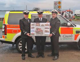 James Larkin (centre) presented with a canvas by new Greenore Coast Guard OIC George Campbell and deputy OIC Shay Gormley