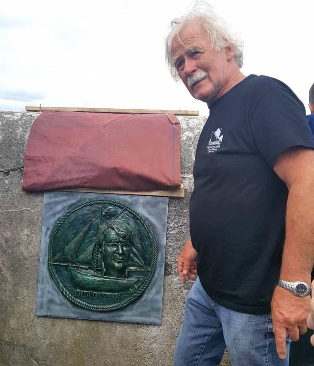 Dr Michael Brogan, Cruinniu organiser, with  the plaque of late Cruinniu founder Tony Moylan designed by John Coll and erected at Kinvara pier.