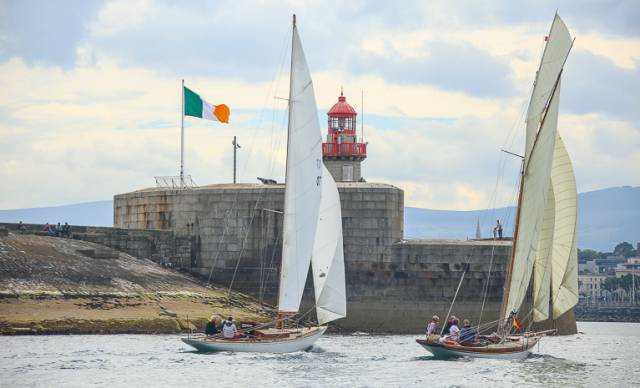 The photo that says a thousand words. Periwinkle and Myfanwy approach Dun Laoghaire harbour towards the finish of the first race on the Kingstown 200 series. To celebrate the 200th Anniversary of Kingstown Harbour, this year’s Volvo Dun Laoghaire Regatta 2017 includes a significant fleet of Classic and Traditional vessels, racing for the Kingstown 200 Trophy. And the fleet is varied in the extreme.  Towards the end of their first race on Thursday - which concluded with an in-harbour finish close off the National YC where the classics are berthed - the leader on the water as expected was the superbly-restored Dublin Bay 24 Periwinkle (David Espey & Chris Craig), an Alfred Mylne design of late 1930s vintage.  But the final leg to the harbour mouth was a long reach in a pleasant sou’easter from the middle of Dublin Bay, and the Welsh visitor Myfanwy, a 36ft cutter designed by Alexander Richardson of Liverpool in 1897 (he also designed John Jameson’s legendary Irex in 1884) was going like a train. Owner Rob Mason recently restored her himself from virtual dereliction. He has given her a fine suit of sails to match her generous spread of canvas, and with a keen crew, Myfanwy was very much a contender, though Periwinkle did stave her off at the very end.  However, it has given us what could well be the photo that symbolises the Kingstown 200 within Volvo Dun Laoghaire Regatta 200. The splendid granite East Pier now looks as though it is a natural part of the environment – you could well imagine it in place when Dublin Bay itself was formed. The crisp, clean and generously-sized tricolour flying proudly tells us there has been a change of management, but one that increasingly respects all that we have inherited from the past. And coming in past the pierhead are two handsome yachts which speak eloquently of our rich sailing history and heritage, as the Dublin Bay 24s were a major and very successful class in the bay from 1947 to 2004, while Myfanwy is a direct link back to a period when John Jameson of Dublin Bay with his mighty Irex was the most successful yacht owner of his era. Photo: David O’Brien/Afloat.ie