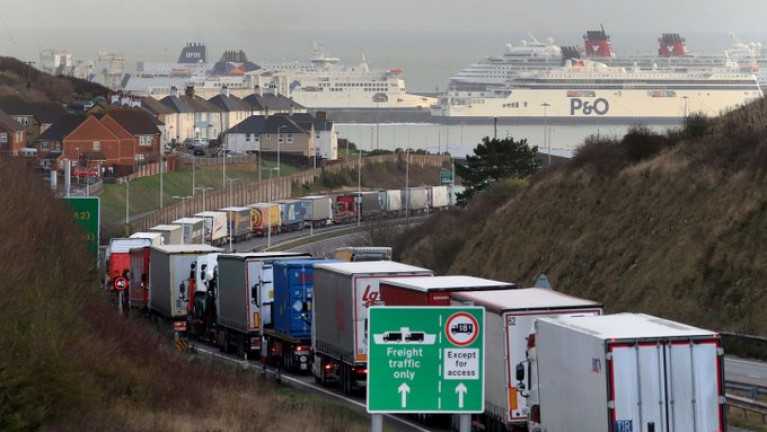 Trucks queue for the Port of Dover: Irish lorries have been caught up in road-side “stacking” of vehicles over the past week. AFLOAT adds ferry operators identified (L-R) DFDS, P&O and a laid-up cruiseship Disney Magic (red funnels) of Disney Cruise Line berthed at the English south-east port in Kent. As Afloat reported last month, DFDS is to launch on 2 January 2021 a new direct freight-only route Rosslare Europort-Dunkirk to bypass post-Brexit congestion, customs checks and clearance. The Danish operator already runs a route from the north French port to Dover but with motorist passengers also included. 