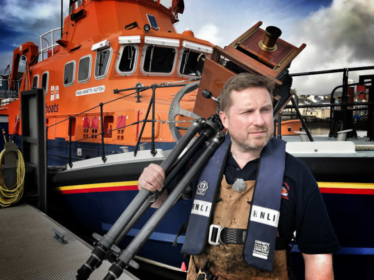 Photographer Jack Lowe with his more-than-a-century-old camera alongside Castletownbere RNLI’s all-weather lifeboat Annette Hutton