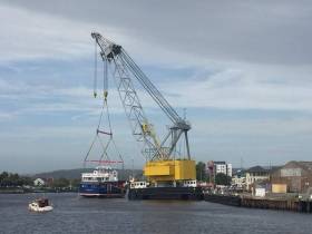 A rare example of an Irish built carferry, Spirit of Rathlin after been lowered onto the River Avoca, Arklow by the giant floating crane-barge, Lara 1
