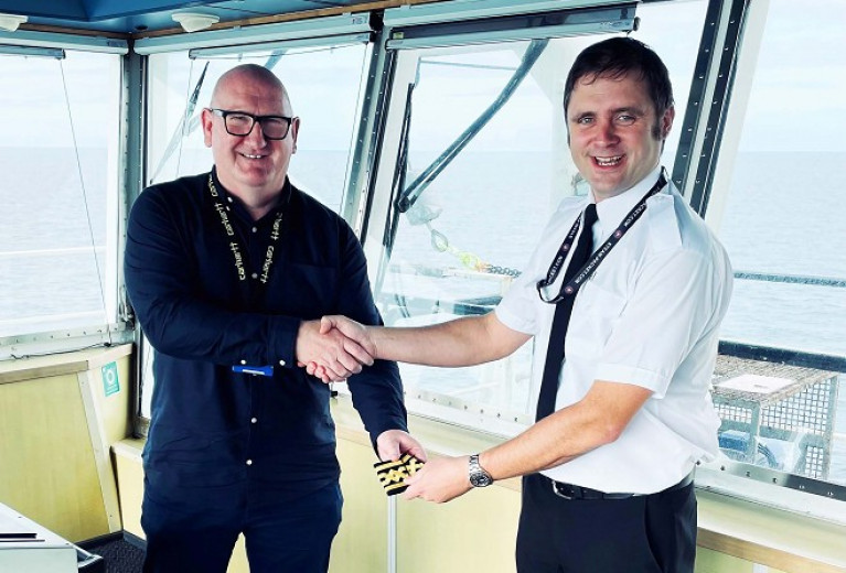 The Isle of Man Steam Packet's M.D. Brian Thomson presenting Scott Kaniewski with his epaulettes on the bridge of the ro-pax Ben-my-Chree Bridge following his promotion to Relief Master of the operator's main ferry. 