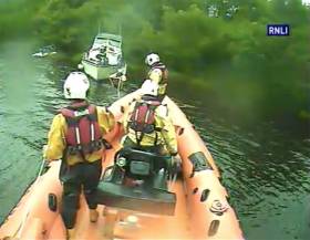 Carrybridge RNLI’s volunteer crew secure a rope to tow a cruiser with motor troubles off the rocks