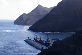 Cargoship MV Helena with the dramatic backdrop of the mountainous coast of St. Helena Island, located in the South Atlantic Ocean. Helena is seen docked in Ropert&#039;s Bay on the first day of arrival (7 March) following a delayed debut on the new freight service from South Africa.