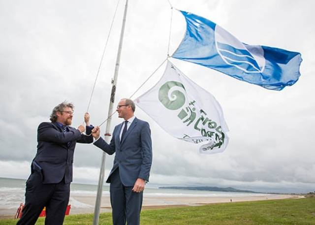 From left Michael John O’Mahony, Director, An Taisce’s Education Unit; and Minister for Environment, Community and Local Government Simon Coveney TD raising the flags on Portmarnock’s Velvet Strand at the announcement of  An Taisce’s Blue Flag and Green Coast Awards 2016