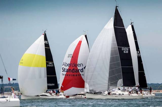 Fools Gold (white spinnaker with yellow band) as a bunch of competitors struggle for clear air at the IRC Europeans on the Solent