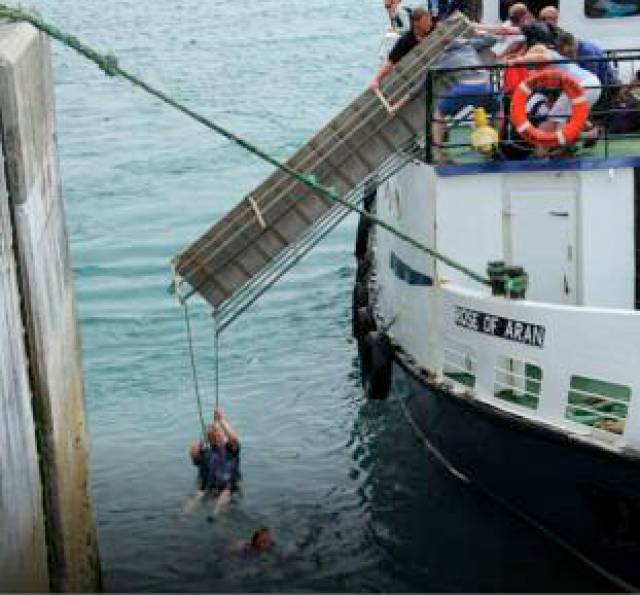 One of the two passengers who entered the water holds onto the end of the gangway of the Rose of Aran before his rescue in the incident on 6 June 2016