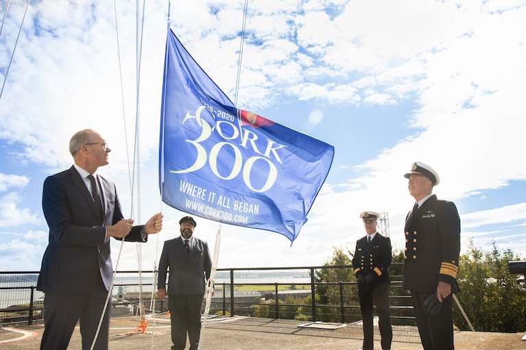 Minister Simon Coveney raises the Cork300 flag with Chief of Staff of the Irish Defence Forces, Vice Admiral Mark Mellett, Flag Officer Commanding Naval Service Commodore Michael Malone, and the Admiral of the Royal Cork Yacht Club Colin Morehead.
