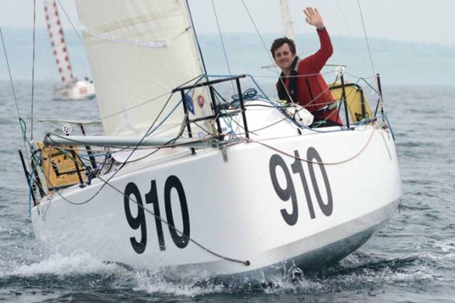 Tom Dolan with his boat, which he finished himself from a bare hull before achieving remarkable racing success. Now it is time for us to rally round in support. He has travelled an incredible distance in solo sailing achievement, but he needs help from all of us to get over the final funding hurdle for the MiniTransat 2017.