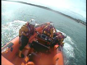 Volunteers on the inshore lifeboat Louis Simson bring the male swimmer back to shore for treatment