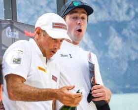 Third overall David Kenefick (right) reacts to the pop of the Champagne cork on the podium at Lake Garda Foiling Week