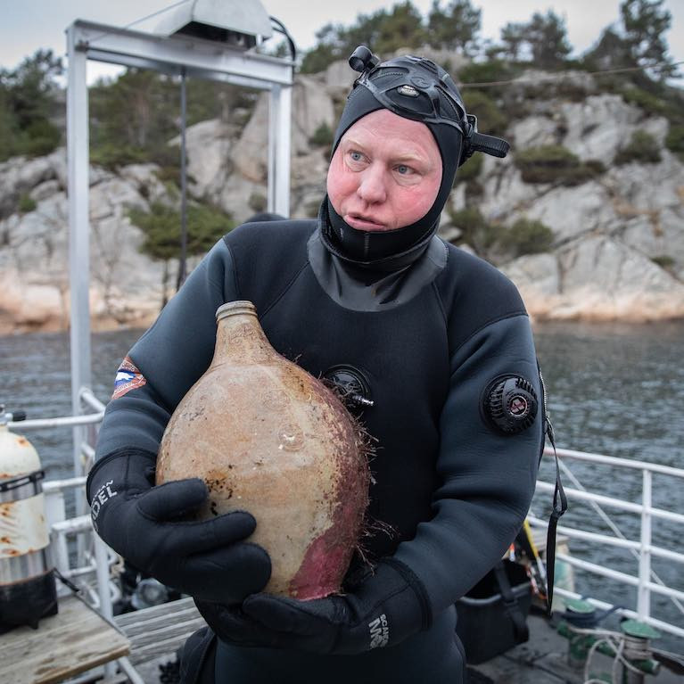 A diver with a bottle from the Irish Sailing Ship &#039;Providentz&#039; that sank in Norway in 1720