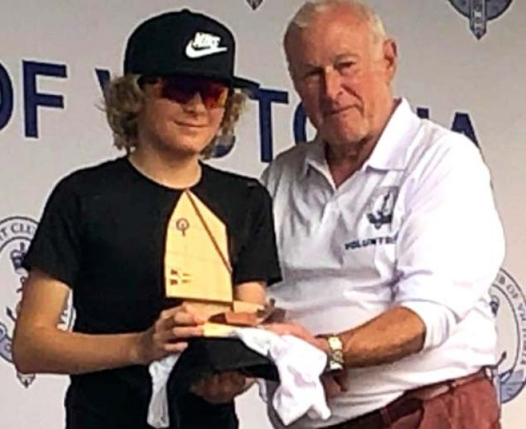 Rocco Wright gets his prize in the Australian Optimist National Opens from the Commodore of the Royal Yacht Club of Victoria in Melbourne